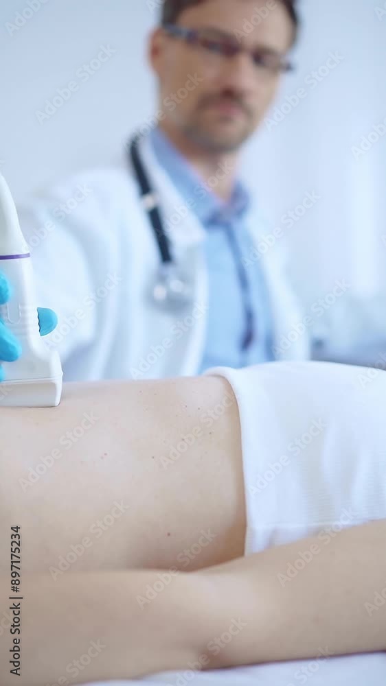 Doctor man wearing a blue protective gloves using an ultrasound machine on a female patient examining internal organs. Medicine concept Doctor man wearing a blue protective gloves using an ultrasound machine on a female patient examining internal organs. Medicine concept