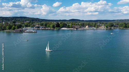 Aerial drone view of yacht on Starnberg See lake, Bavaria Germany. Recreation and relaxation area with beach, cafe and forest.