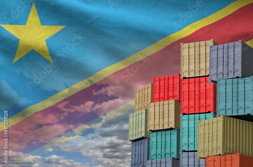 Democratic Republic of the Congo flag and big stack of shipping cargo containers in docks with sky background close up photo