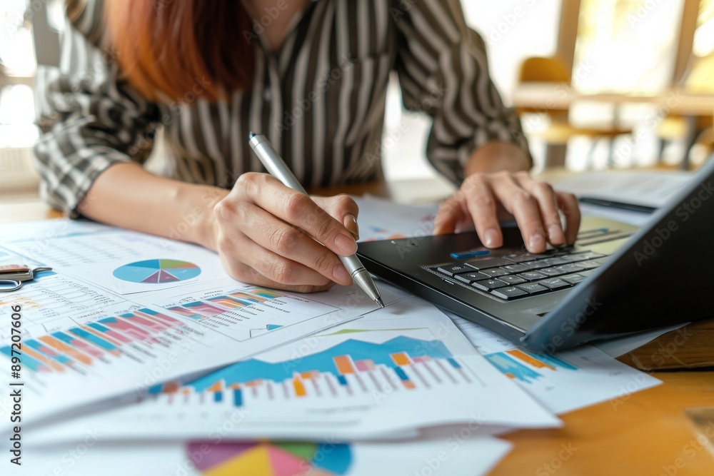 A focused woman sits at a table, diligently working on her laptop, Financial paper reports being analyzed by an accountant, AI Generated A focused woman sits at a table, diligently working on her laptop, Financial paper reports being analyzed by an accountant, AI Generated