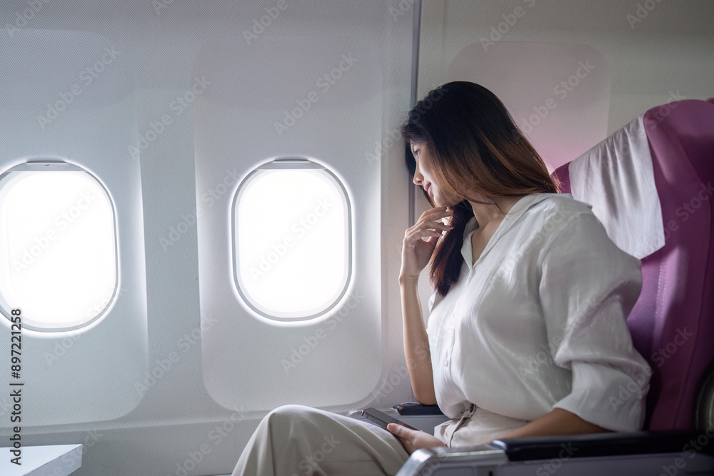 Businesswoman Traveling by Airplane, Looking Out Window, Reflecting on Business Trip and Future Opportunities Businesswoman Traveling by Airplane, Looking Out Window, Reflecting on Business Trip and Future Opportunities