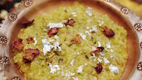 Indian sweet dish Doodhi or locky ka Halwa.  bottle gourd sweet in a bowl isolated with dry rose leaf. photo