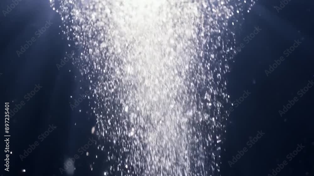 A stream of small, white bubbles rise through a dark blue liquid, illuminated by bright light above. A stream of small, white bubbles rise through a dark blue liquid, illuminated by bright light above.
