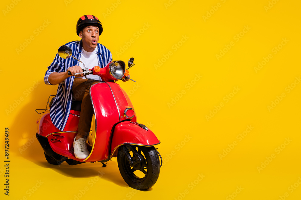 Full size photo of astonished man dressed shirt in helmet driving motorcycle staring at empty space isolated on vivid color background Full size photo of astonished man dressed shirt in helmet driving motorcycle staring at empty space isolated on vivid color background