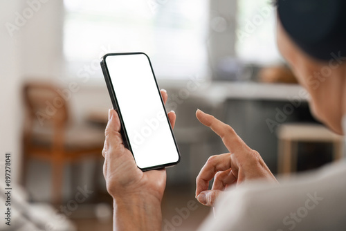 Person Using Smartphone with Blank Screen in Modern Home Office Setting