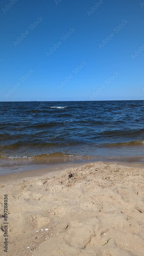 Baltic sea, no people at sea and on the beach, sand, blue sky without clouds, waves, daytime