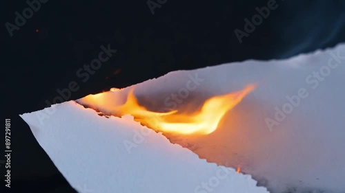 Burning white paper. burning paper, glowing edge of paper on a black background photo