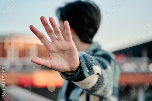 Papier peint young asian man covering his face in a stop sign