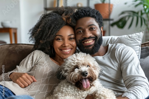 Portrait of a smiling afro-american couple in their 30s relaxing with their dog on the sofa