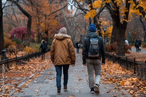 Two individuals walk down a leaf-covered path in an autumn park, capturing the essence of seasonal transition, personal journey, and the beauty of fall colors. photo