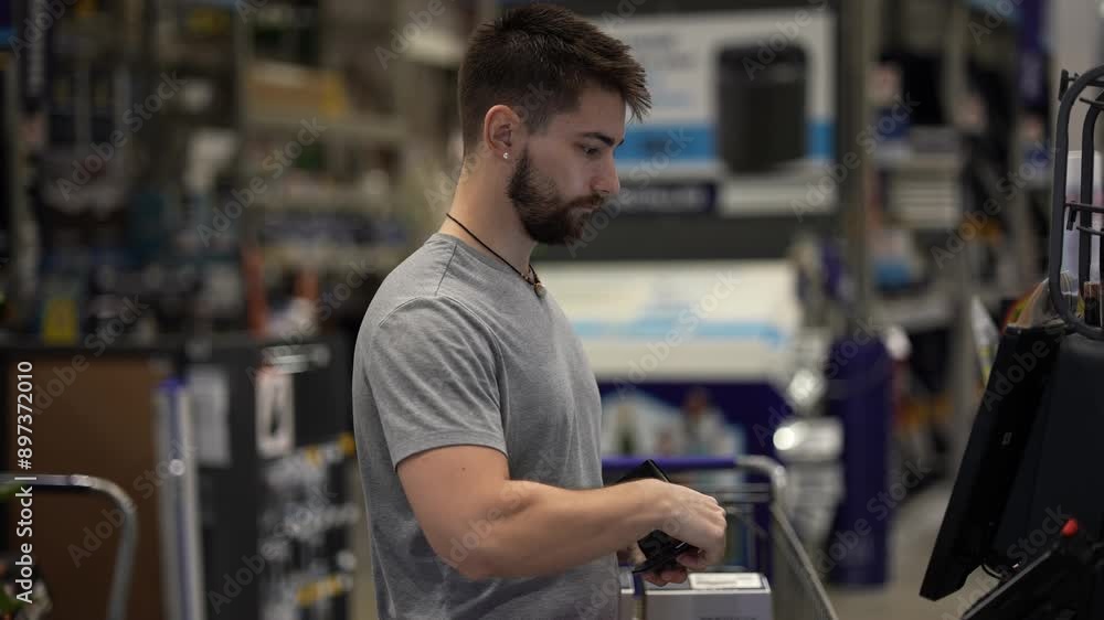 Man at self checkout in hardware store. Man at self checkout in hardware store.
