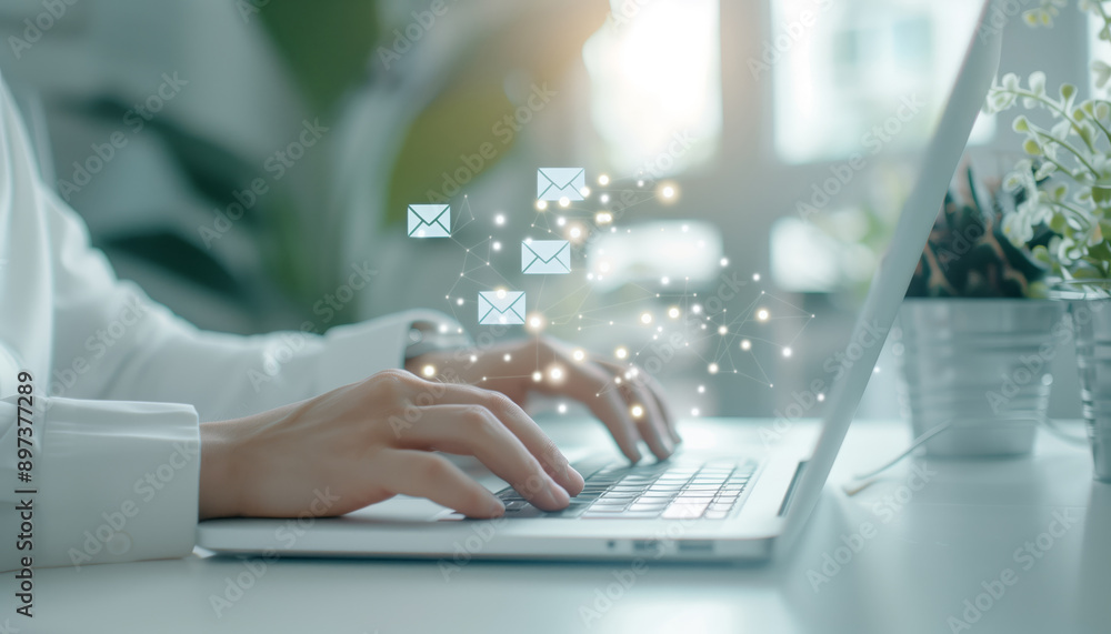 Close-up of hands typing on a laptop, with email icons floating above, symbolizing digital communication and productivity. Close-up of hands typing on a laptop, with email icons floating above, symbolizing digital communication and productivity.