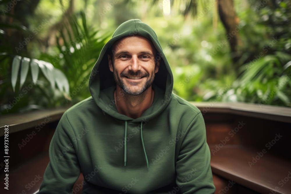 Portrait of a content man in his 40s sporting a comfortable hoodie in front of lush tropical rainforest Portrait of a content man in his 40s sporting a comfortable hoodie in front of lush tropical rainforest