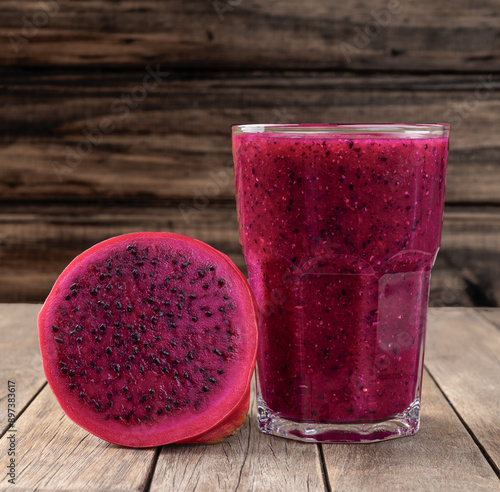 Pitaia or dragon fruit juice with fruits over wooden table photo