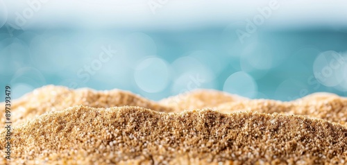 Featuring golden sand and blue sea water, this blurred background of a summer beach with a bokeh blur effect provides ample copy space for product display presentation design concepts. photo