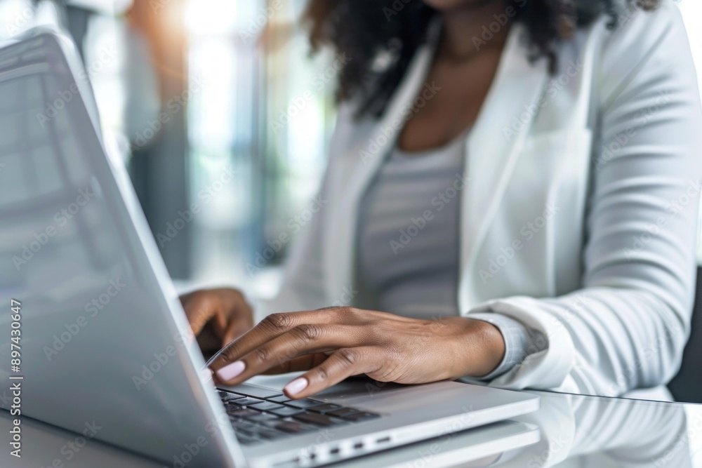 Businesswoman is working on a laptop in a bright office Businesswoman is working on a laptop in a bright office