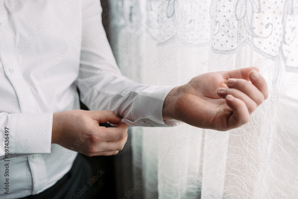 A man is getting dressed and adjusting his shirt. Concept of preparation and attention to detail