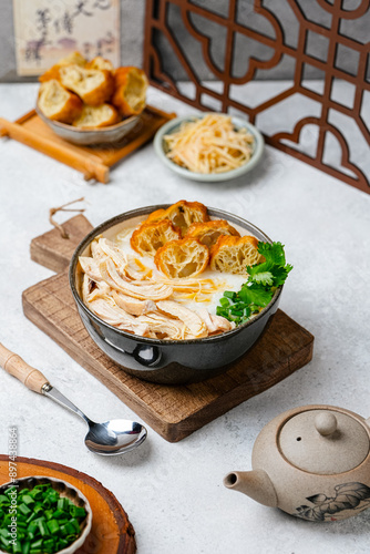 Shredded chicken porridge with ginger, cakwe and spring onions photo