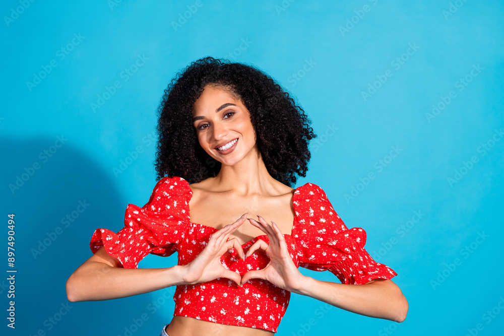 Portrait of gorgeous young woman show heart symbol wear top isolated on blue color background Portrait of gorgeous young woman show heart symbol wear top isolated on blue color background
