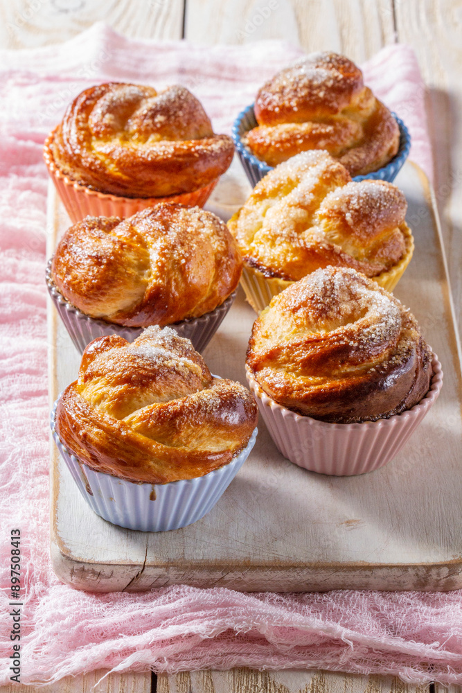 Rose-shaped yeast dough buns sprinkled with sugar in ceramic molds.