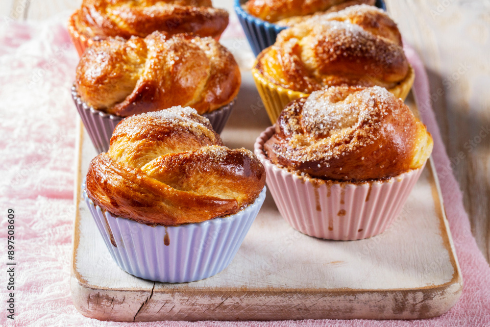 Rose-shaped yeast dough buns sprinkled with sugar in ceramic molds.