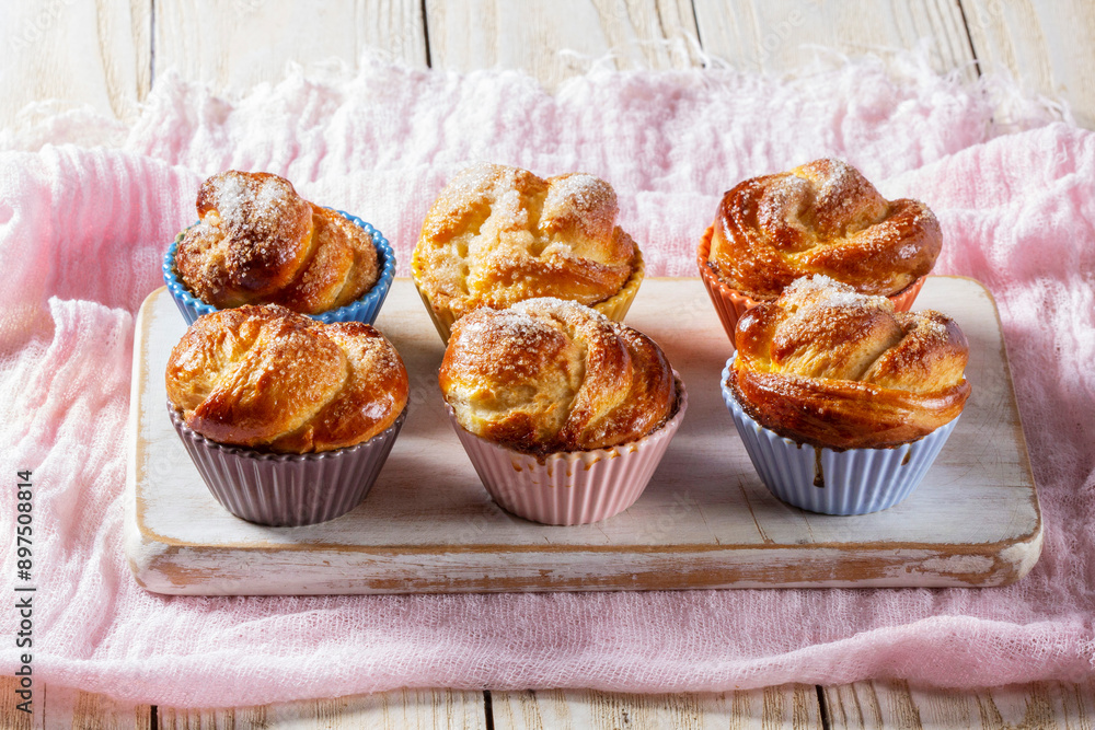 Rose-shaped yeast dough buns sprinkled with sugar in ceramic molds.