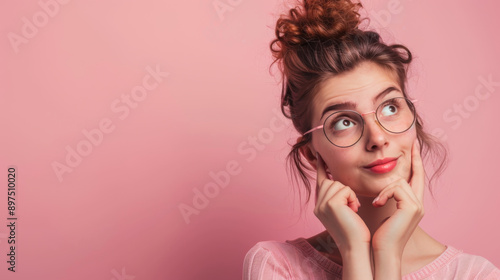 Wallpaper Mural Surprised woman in glasses holds her finger to her face on a pink background. A beautiful woman fantasizes indoors. Concept of beauty, fun. Torontodigital.ca