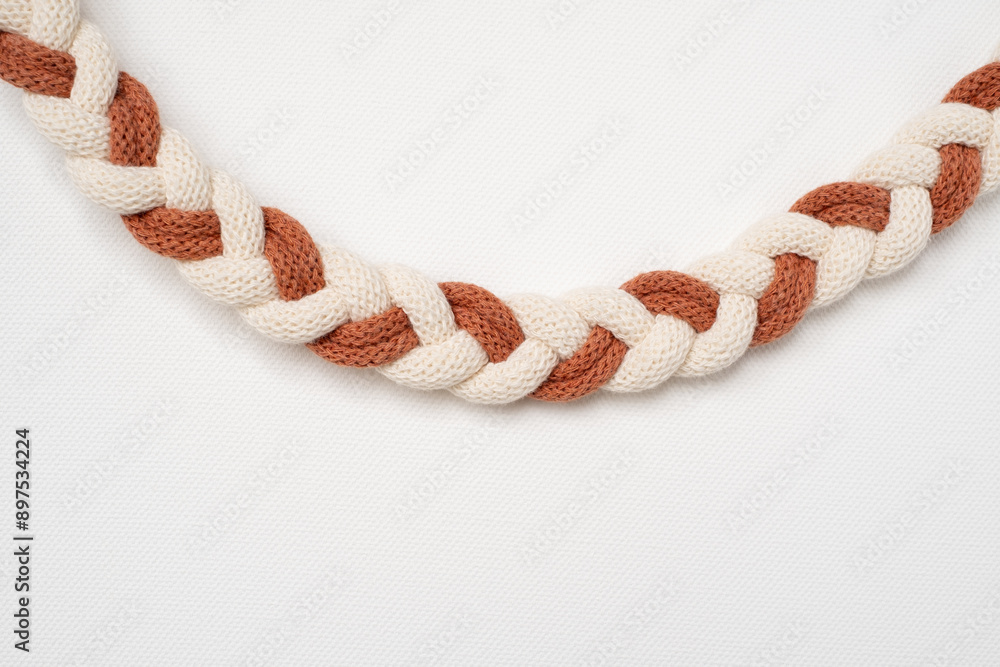 Braided macrame cords. Macrame strings tied together forming a braid Braided macrame cords. Macrame strings tied together forming a braid