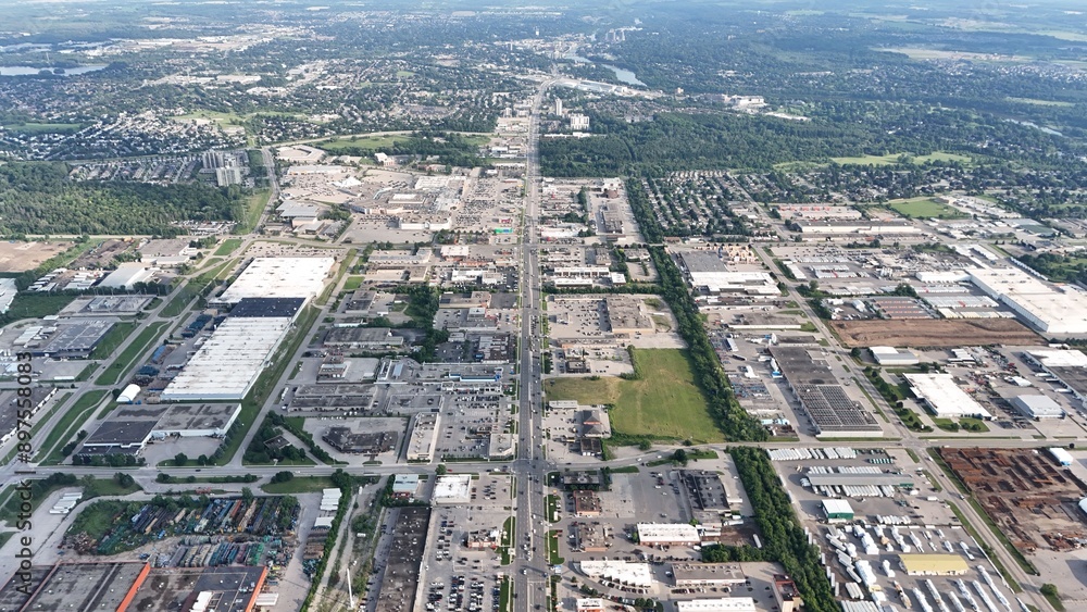 Fototapeta premium Aerial view of an urban industrial area with various buildings and greenery in the background