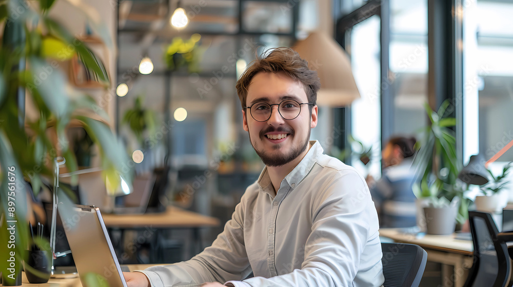 Bright Outlook: Young Professional Smiling at Desk Bright Outlook: Young Professional Smiling at Desk