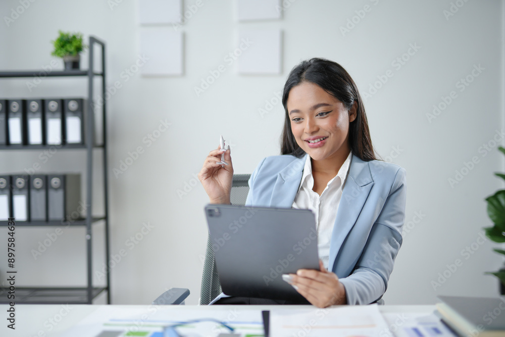 Young professional travel agent planning a trip with a tablet and holding a small airplane model in her office Young professional travel agent planning a trip with a tablet and holding a small airplane model in her office