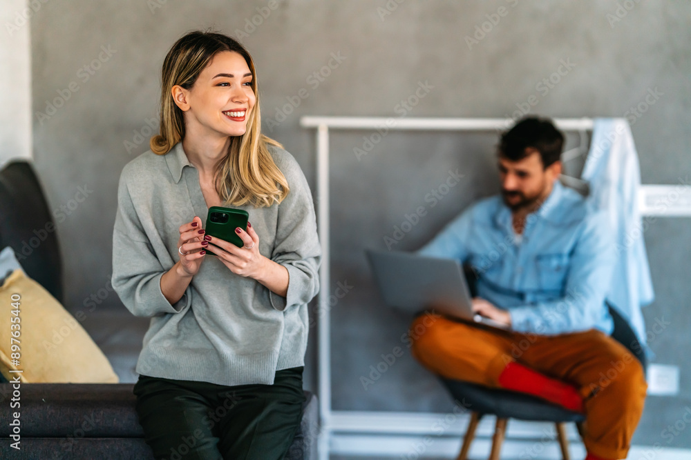 Smiling young woman chatting in social networks, working, using mobile applications at home. Smiling young woman chatting in social networks, working, using mobile applications at home.