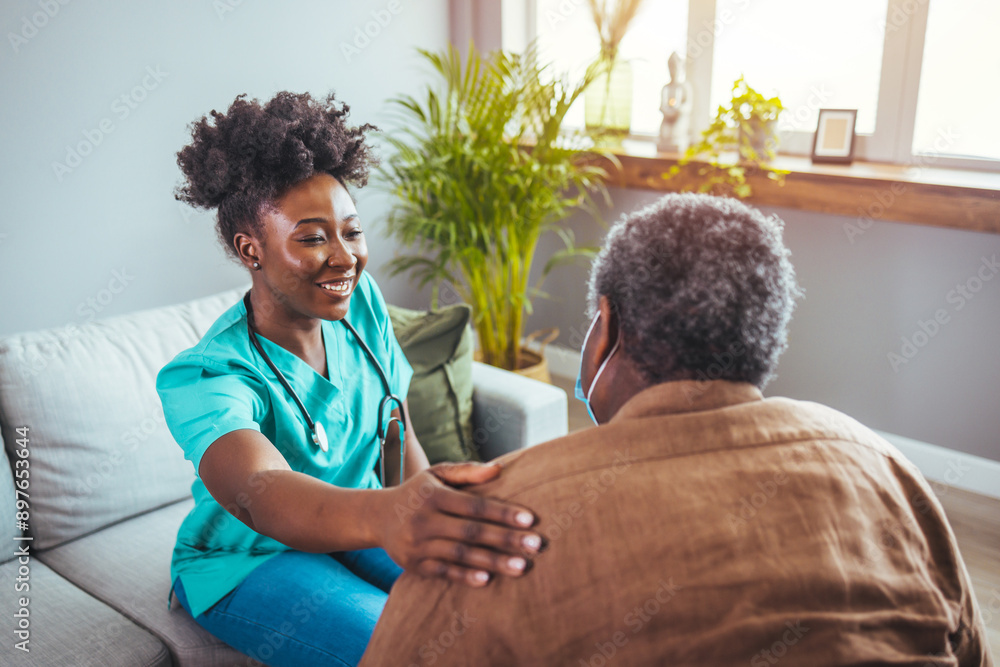 Obraz premium A mid-adult Black nurse in scrubs engages with an elderly man in a home setting, providing attentive healthcare assistance with warmth and professionalism