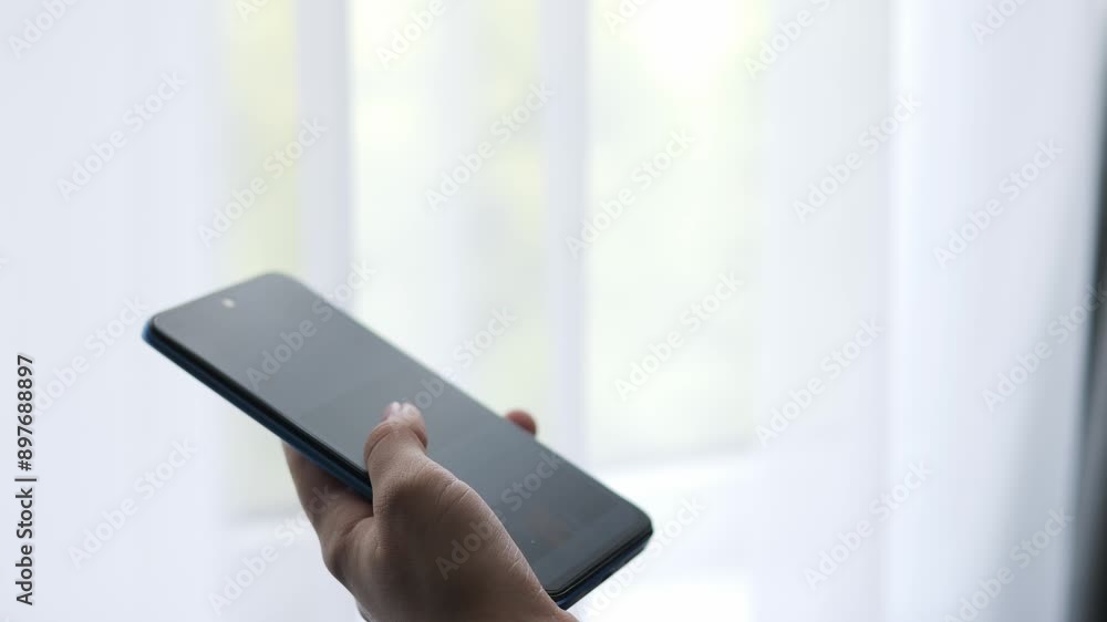 The girl holds the phone in her hands. A woman scrolls with her fingers on a touchscreen smartphone. The girl holds the phone in her hands. A woman scrolls with her fingers on a touchscreen smartphone.