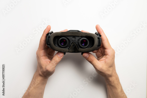 Male hands hold virtual reality glasses. First-person view. On a white background. VR concept