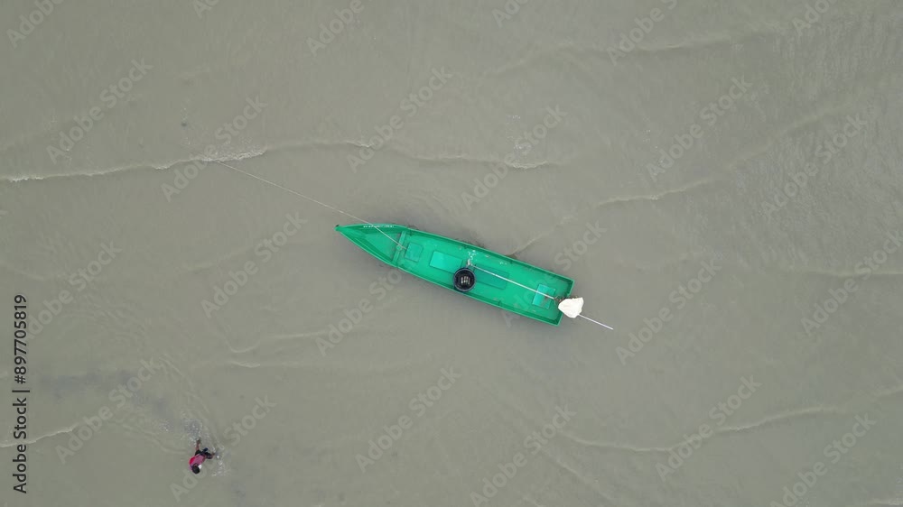 파타야 북부 어촌마을 나끌루아 해변의 갯벌에 여유롭게 떠있는 초록색 배 한척