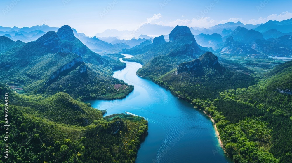 Aerial view of blue water river winding through mountains, surrounded by dense greenery and clear skies Aerial view of blue water river winding through mountains, surrounded by dense greenery and clear skies