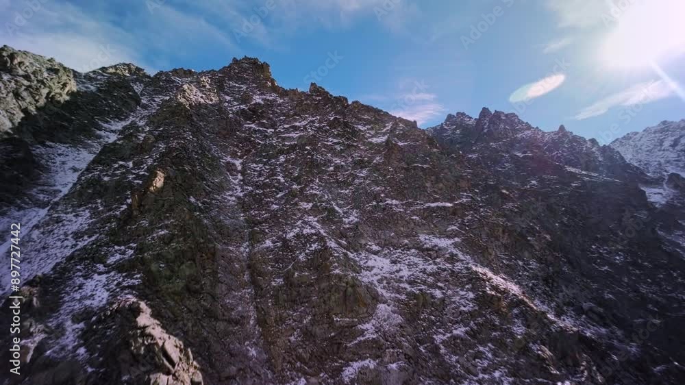 Aerial view, climbing to the top of the mountain preparing for a dive from the upper ridge, alpine sunny landscape. Sports drone with first person view, epic rocky landscape. Aerial view, climbing to the top of the mountain preparing for a dive from the upper ridge, alpine sunny landscape. Sports drone with first person view, epic rocky landscape.