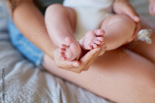 Bedroom, woman and hand with feet of baby for development, support and growth of child in infancy. Love, care and mom with infant kid at home for connection, bonding and protection in motherhood © peopleimages.com