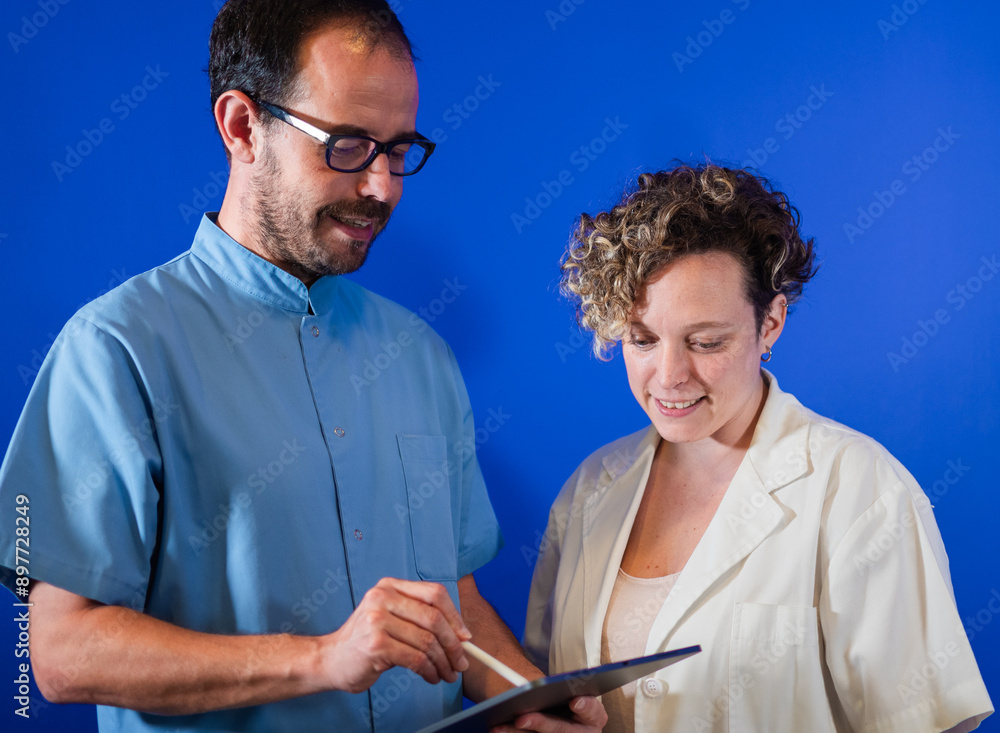 Obraz premium Doctors discussing patient records on a digital tablet