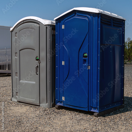 Two porta potty toilets outside near raceway.