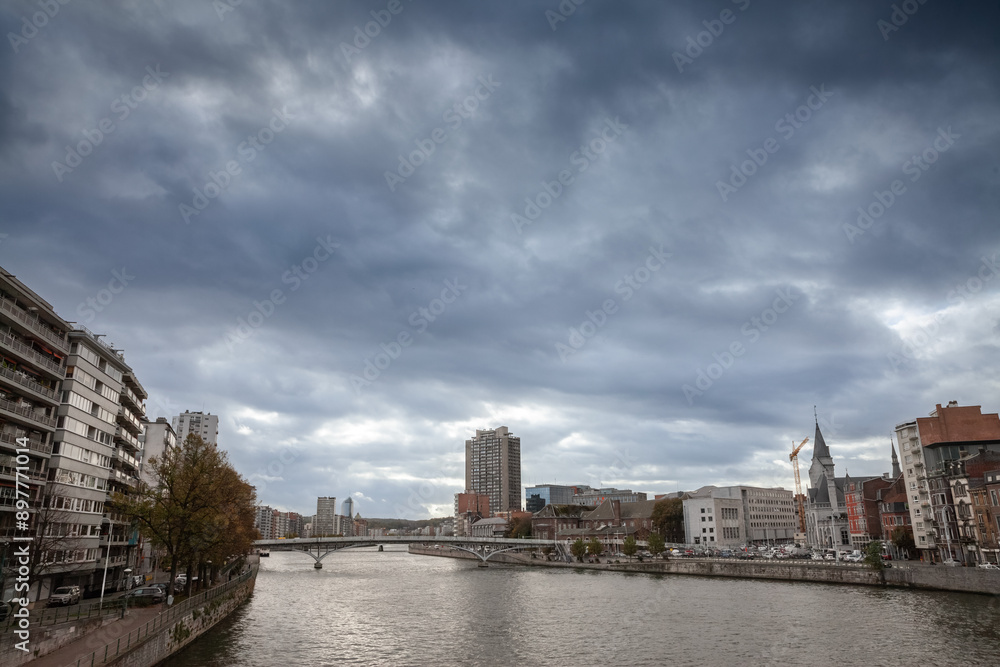 Naklejka premium Panorama of the city center of Liege, Belgium, during a cloudy afternoon of autumn, in centre ville, with the meuse river (maas) in front. Liege is one of the biggest cities of Belgium and Wallonia.