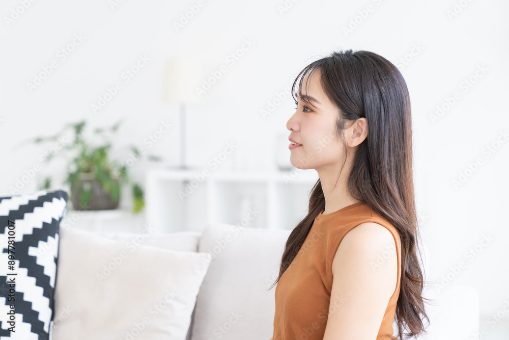 部屋でリラックスする若い女性