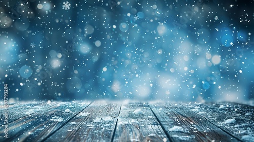 frosty winter background with falling snow sparkling flakes and wooden floor blurred blue backdrop