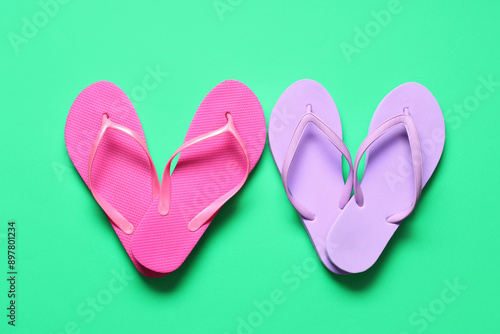 Hearts made of different flip-flops on green background