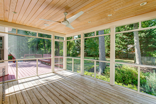 Obraz na płótnie Cozy Screened-In Porch With Ceiling Fan And Deck Overlooking Green Backyard w salonie