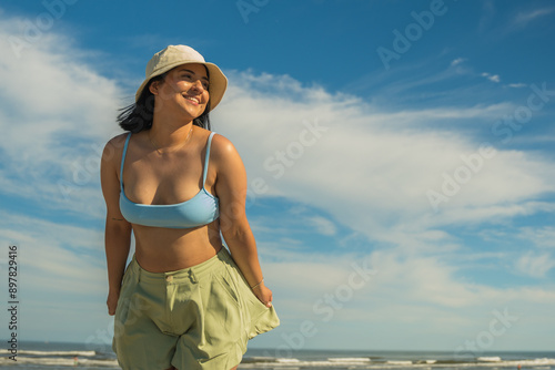 Fotografie Beautiful cute latina hispanic young woman, enjoying her day on the beach, she i