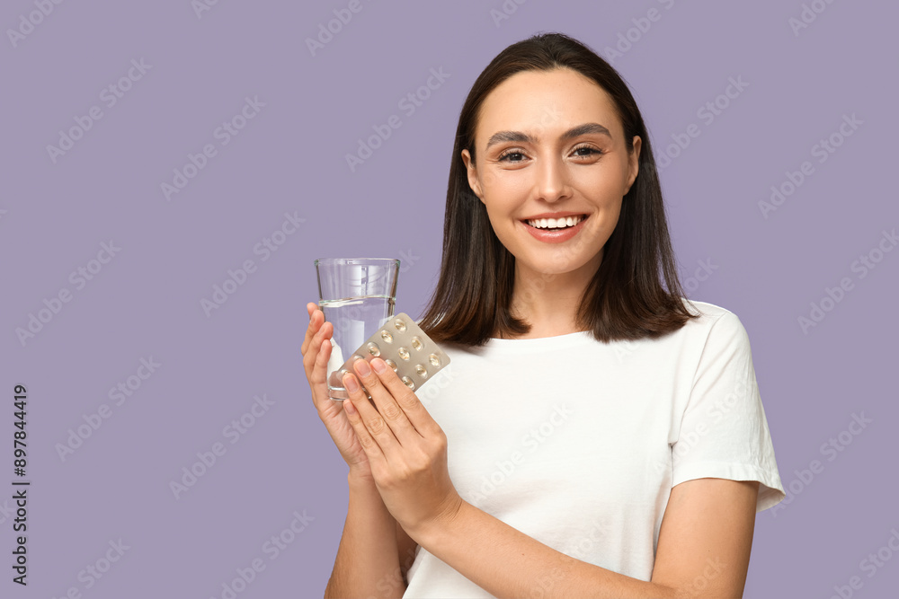 Pretty young woman with glass of water and pills on lilac background Pretty young woman with glass of water and pills on lilac background
