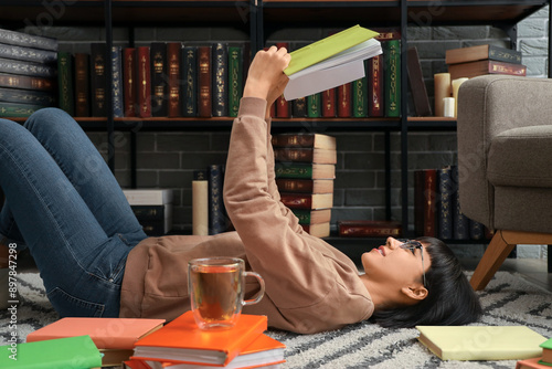 Young woman reading book on...