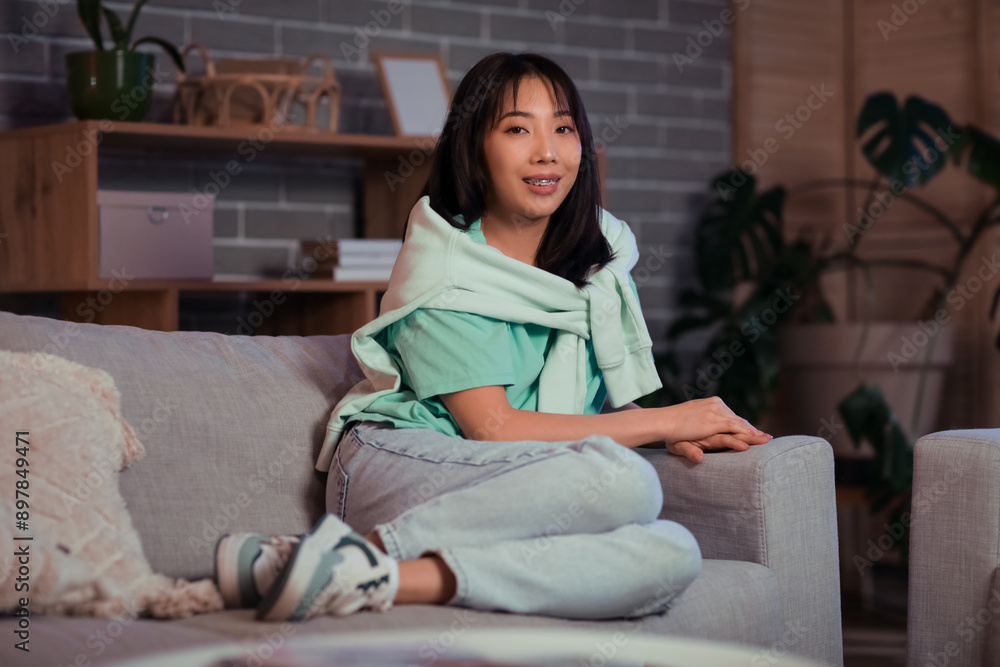 Young Asian woman relaxing at evening in living room Young Asian woman relaxing at evening in living room